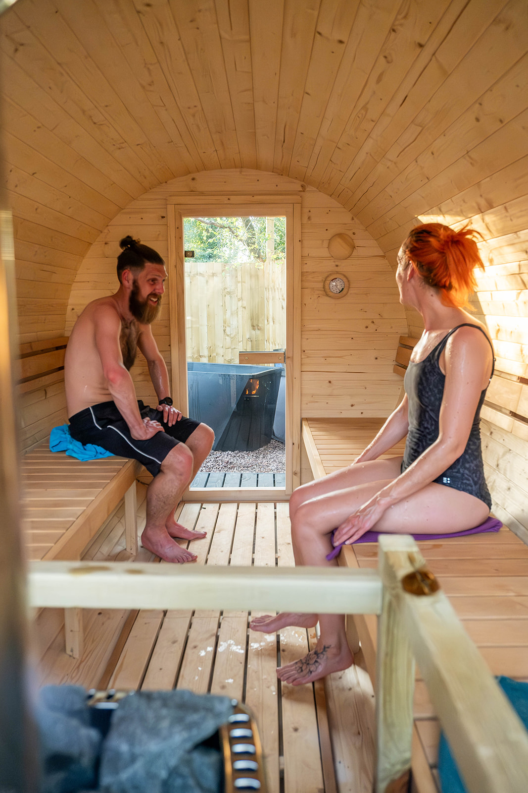 Two people sitting in a wood-fired sauna
