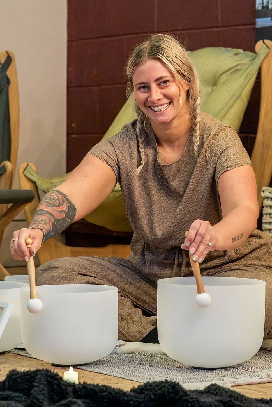 A practitioner playing crystal singing bowls